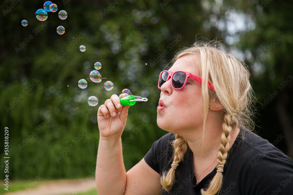 Child carer blowing bubbles outside Child carer blowing bubbles outside