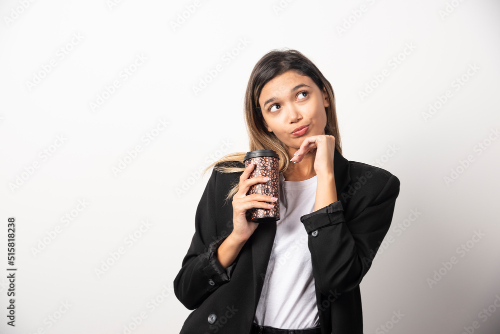 Business woman holding cup and posing on white background Business woman holding cup and posing on white background