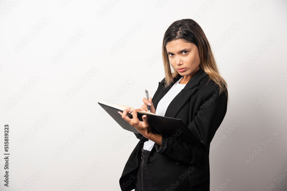 Young businesswoman writing in clipboard with pencil Young businesswoman writing in clipboard with pencil