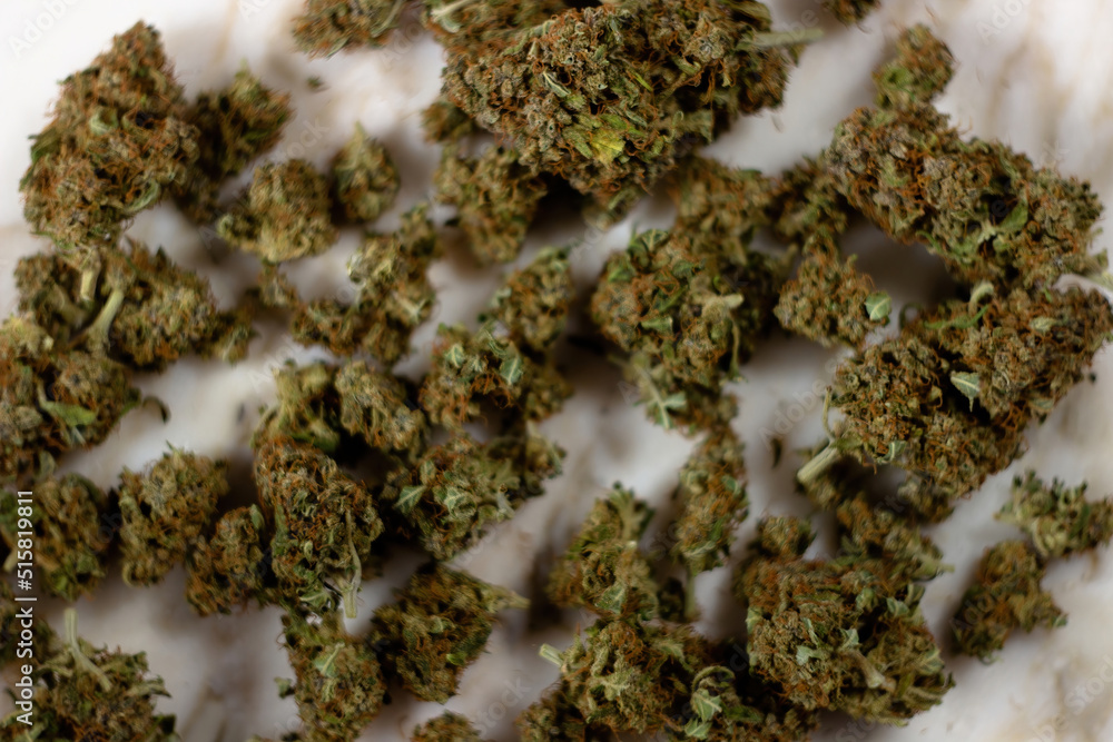 Dried buds of medical marijuana lie on a marble background Dried buds of medical marijuana lie on a marble background