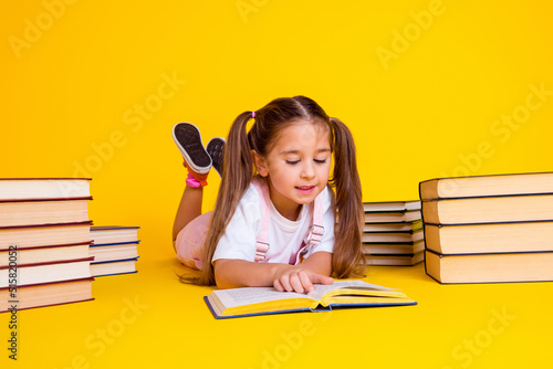 Photo of adorable busy preschool lady dressed pink clothes reading fairytale isolated yellow color background photo