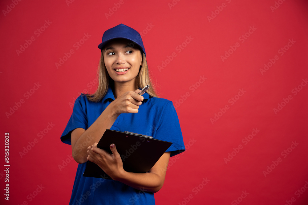 Smiling woman in blue uniform posing with clipboard and pencil Smiling woman in blue uniform posing with clipboard and pencil