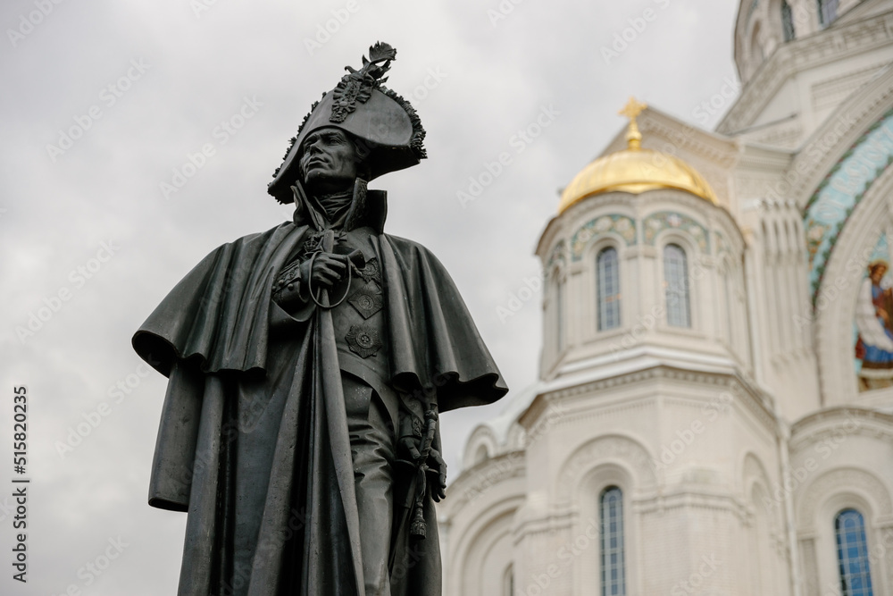 Fototapeta premium Monument to Admiral Fyodor Ushakov on the background of the Naval Cathedral of St. Nicholas the Wonderworker, Kotlin Island. Russia, Kronstadt, 7.07.2022