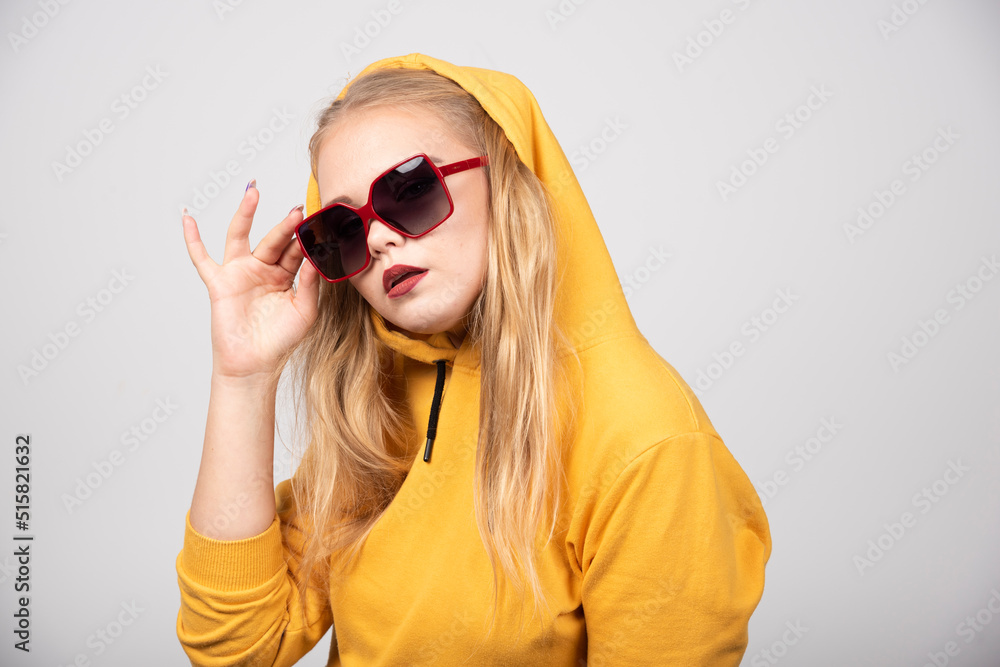 Portrait of pretty girl in yellow hoodie wearing stylish glasses Portrait of pretty girl in yellow hoodie wearing stylish glasses