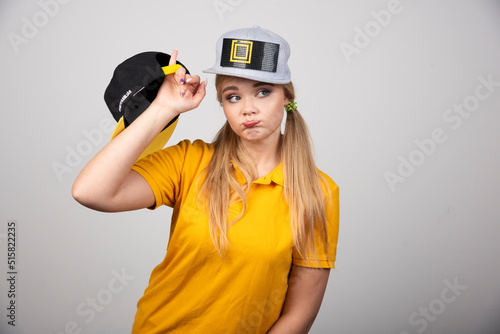 Young woman in stylish t-shirt and a cap on gray background © azerbaijan-stockers