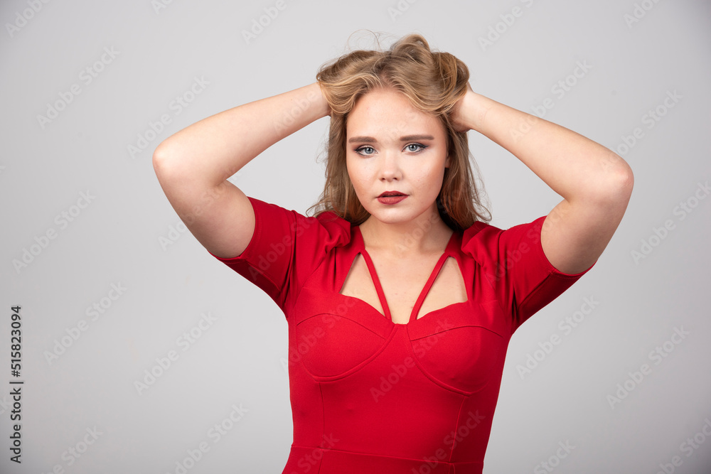 Blonde woman in red outfit holding her hair Blonde woman in red outfit holding her hair