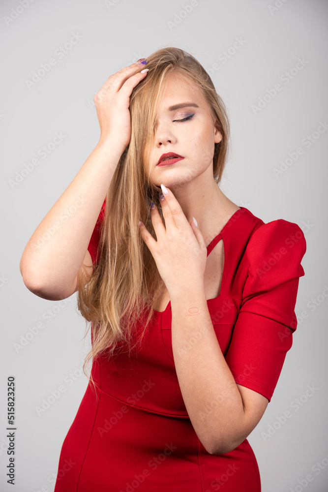 Blonde woman in red outfit holding her hair Blonde woman in red outfit holding her hair
