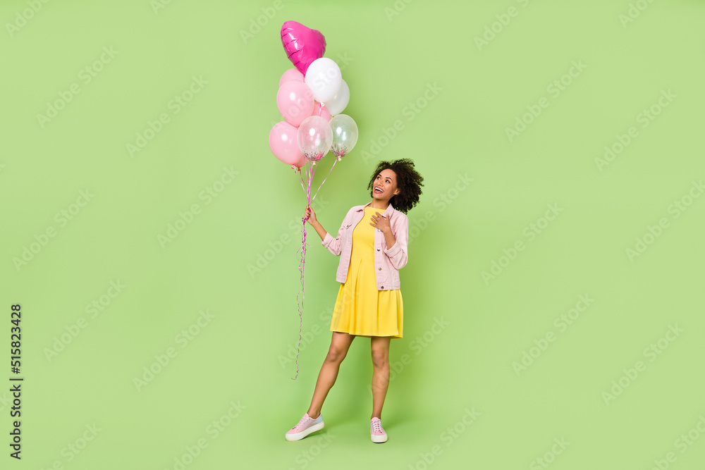 Full body portrait of lovely girl hand chest look balloons wear short mini dress isolated on green color background