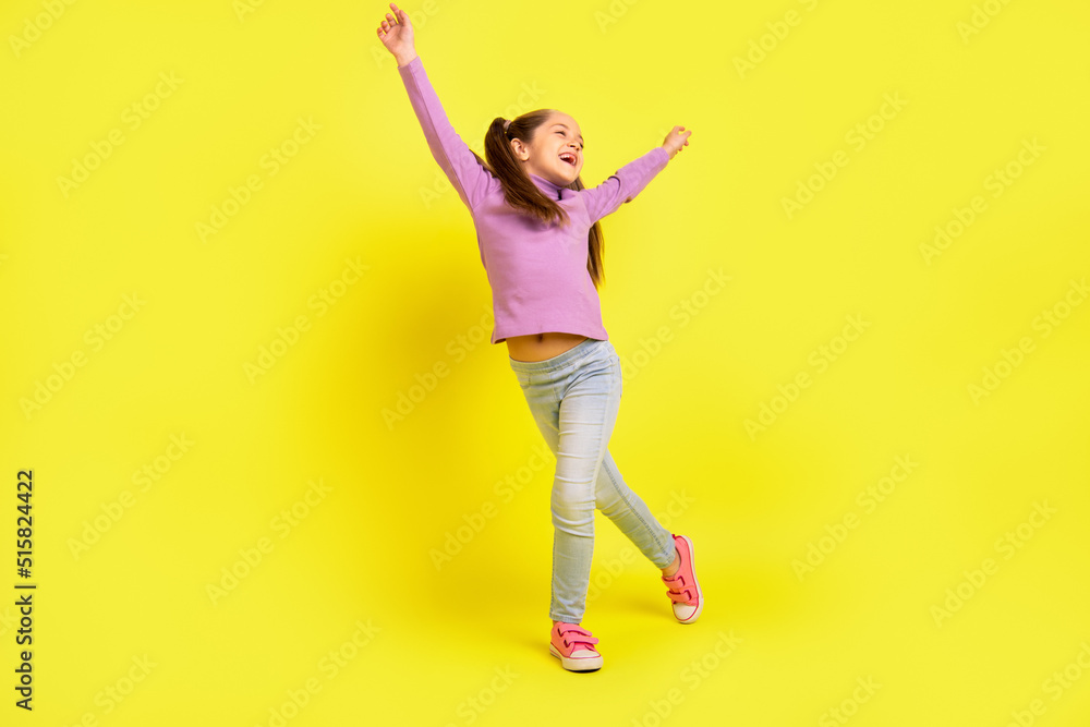 Fototapeta premium Full length photo of positive cheerful school kid dancing energetic raise hands up isolated shine color background