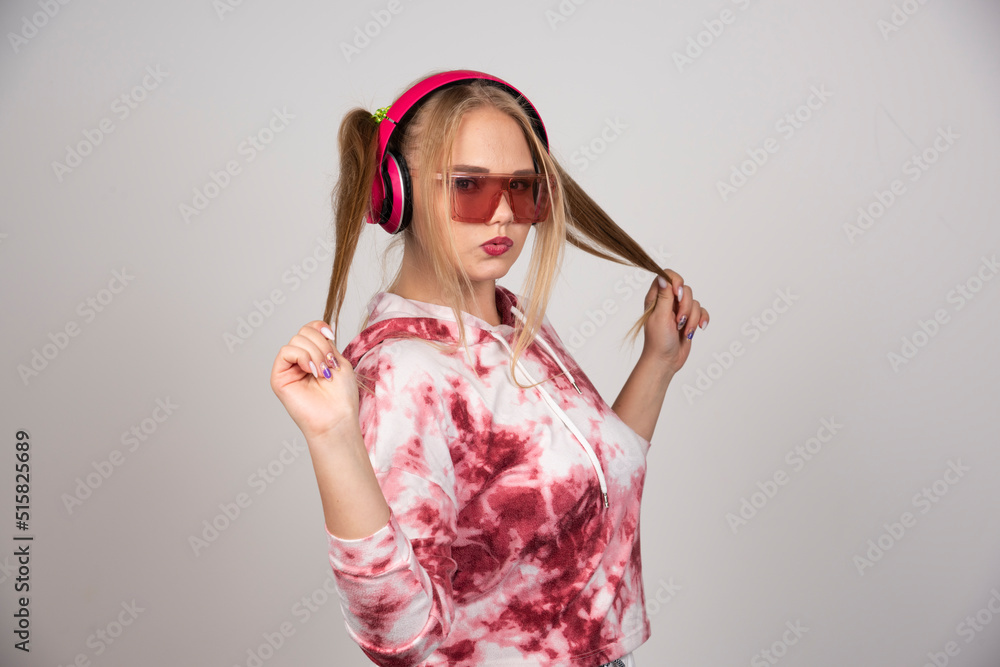 Beautiful young woman in pink outfit holding her hair Beautiful young woman in pink outfit holding her hair
