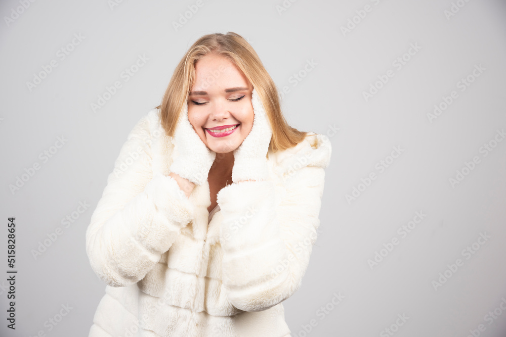 Beautiful woman in winter outfit covering her ears Beautiful woman in winter outfit covering her ears