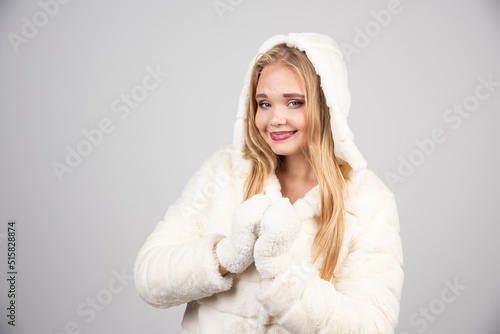 Blonde woman in winter outfit posing happily