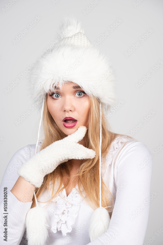 Portrait of blonde woman in winter outfit standing on gray background Portrait of blonde woman in winter outfit standing on gray background