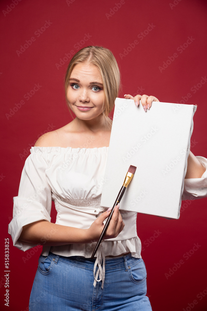 Blonde artist showing her artwork with joyful confidence Blonde artist showing her artwork with joyful confidence
