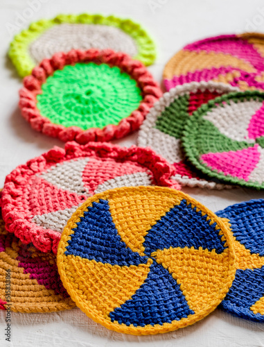 Many bright clolored spiral coasters for hot. Eco friendly handmade crochet coaster with tunisian pattern. photo