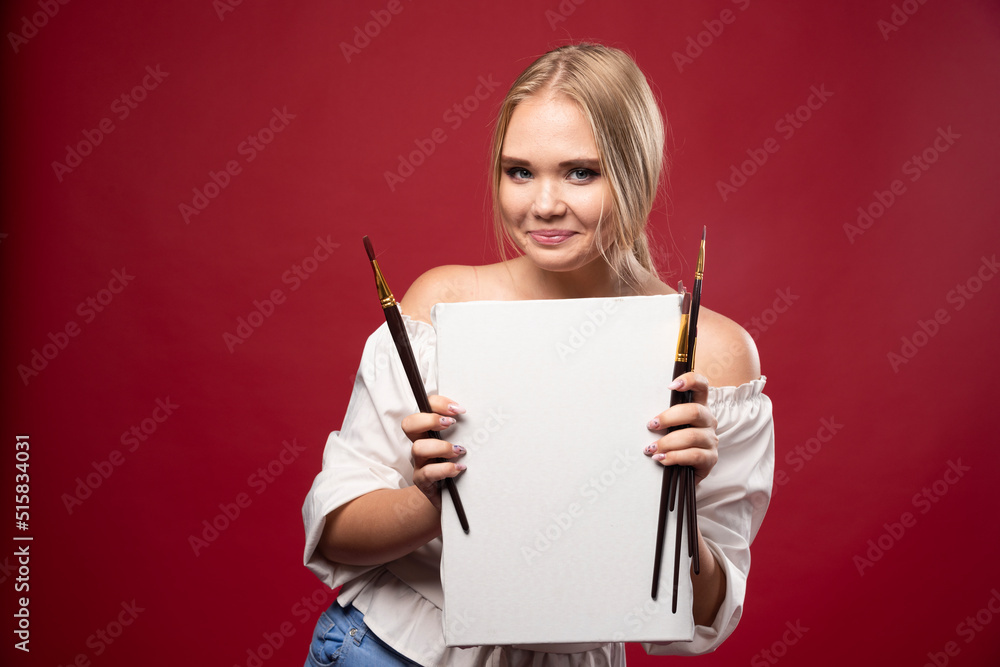 Blonde artist showing her artwork with joyful confidence Blonde artist showing her artwork with joyful confidence