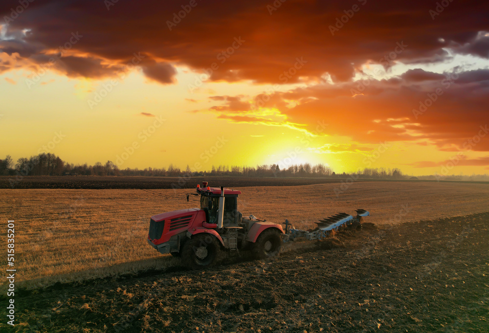 Tractor Plowing field on sunset. Cultivated land and soil tillage. Tractor with disc cultivator on land cultivating. Agricultural tractor on cultivation field. Tractor disk harrow on plowing field. Tractor Plowing field on sunset. Cultivated land and soil tillage. Tractor with disc cultivator on land cultivating. Agricultural tractor on cultivation field. Tractor disk harrow on plowing field.