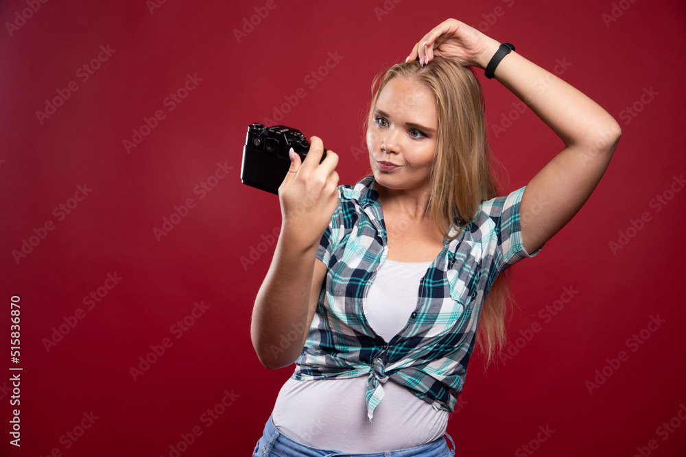Young blonde photograph holding a professional camera and takes her selfie in lovely and confident positions Young blonde photograph holding a professional camera and takes her selfie in lovely and confident positions