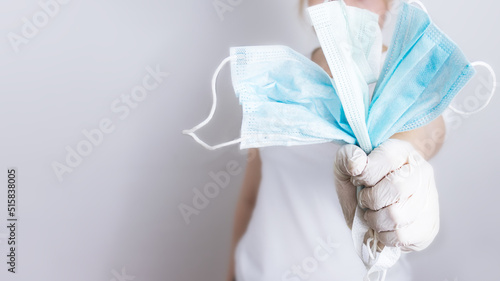 woman clutches a surgical mask in her hands, the concept of the end of a viral epidemic, Cancellation of the norm of wearing masks in public places and crowded places,selective focus,cancel masks, can