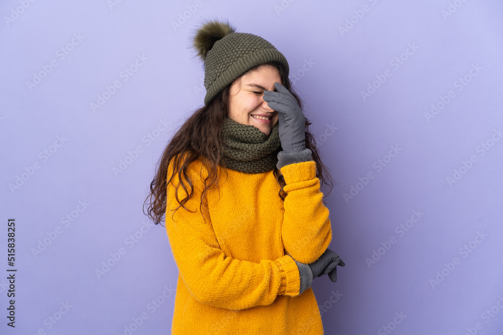 Teenager Russian girl with winter hat isolated on purple background laughing Teenager Russian girl with winter hat isolated on purple background laughing