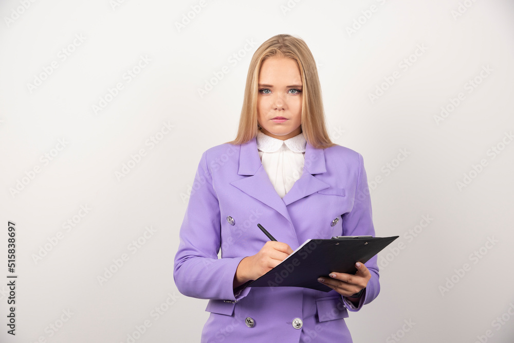 Portrait of young business woman standing and holding clipboard Portrait of young business woman standing and holding clipboard
