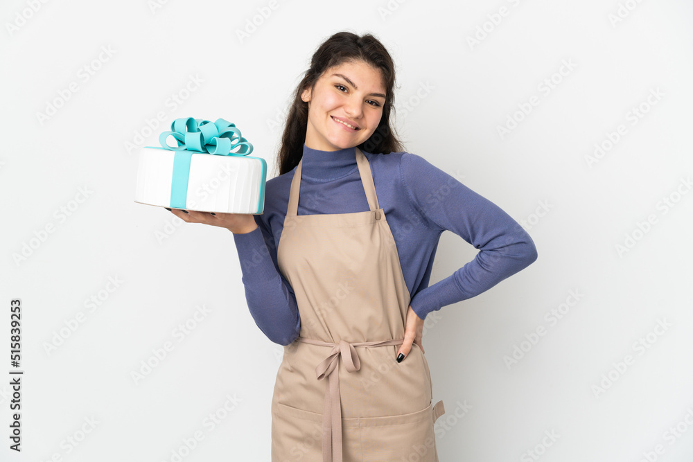 Pastry Russian chef holding a big cake isolated on white background posing with arms at hip and smiling Pastry Russian chef holding a big cake isolated on white background posing with arms at hip and smiling