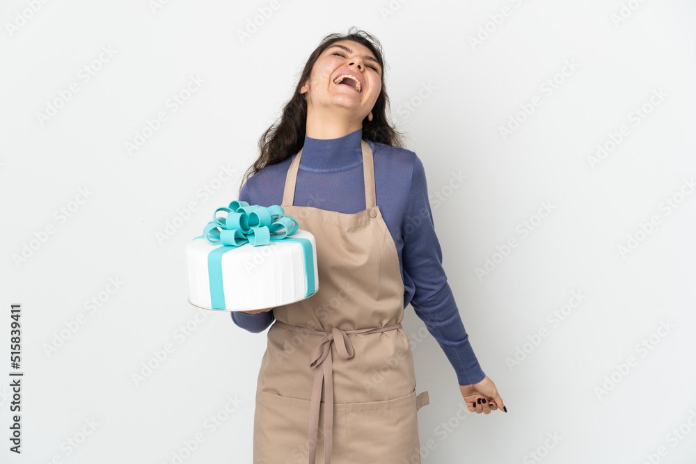 Pastry Russian chef holding a big cake isolated on white background laughing