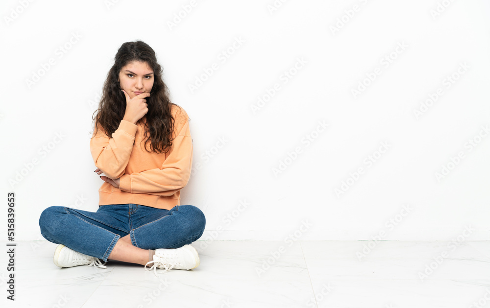 Teenager Russian girl sitting on the floor thinking Teenager Russian girl sitting on the floor thinking