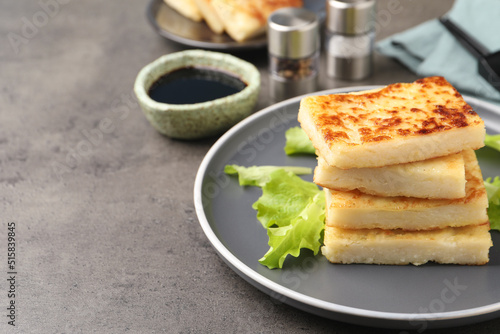 Delicious turnip cake with lettuce salad served on grey table. Space for text