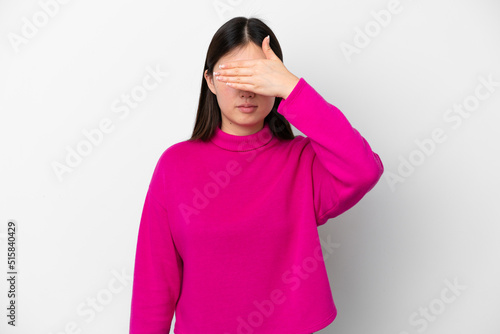 Young Chinese woman isolated on white background covering eyes by hands. Do not want to see something © luismolinero