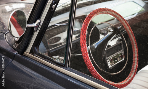 Billede på lærred Red steering wheel and rearview mirror, old timer