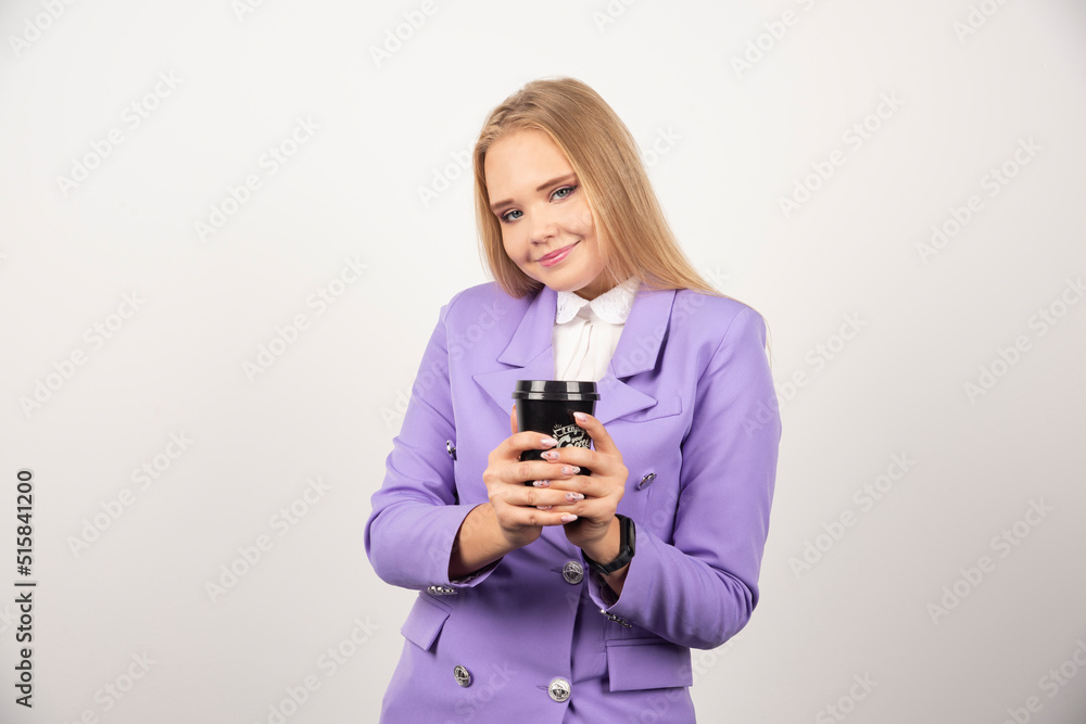 Smiling woman showing cup of coffee on white background Smiling woman showing cup of coffee on white background