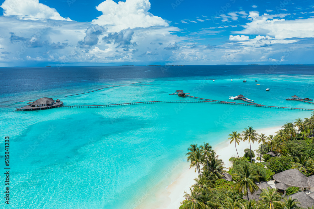 Fototapeta premium Maldives travel paradise. Tropical aerial landscape, seascape with long pier pathway, water villas in amazing sea lagoon beach shore, tropical nature. Exotic tourism destination banner summer vacation
