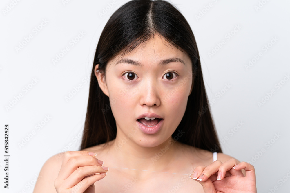 Young Chinese woman isolated on white background with dental floss. Close up portrait Young Chinese woman isolated on white background with dental floss. Close up portrait