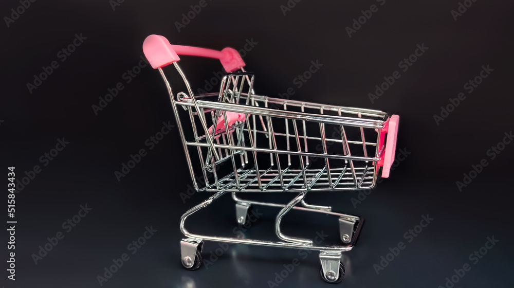 Grocery cart on wheels on a black background. Grocery cart on wheels on a black background.
