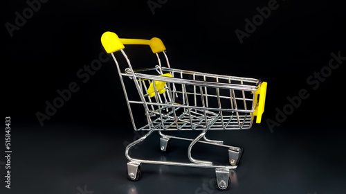 Grocery cart on wheels on a black background.