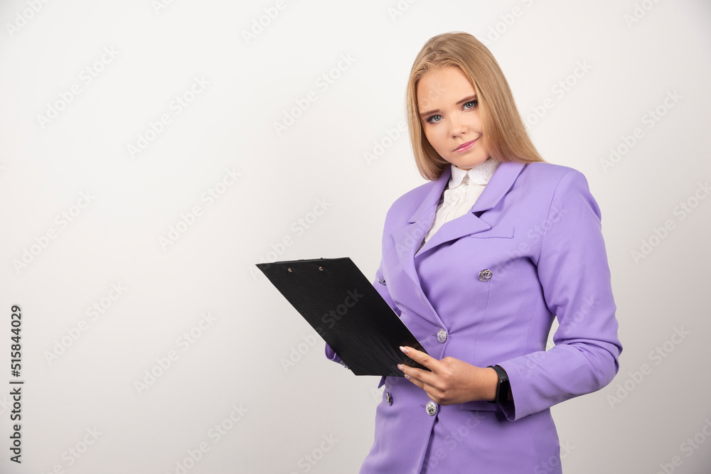 Portrait of smiling business woman standing and holding clipboard Portrait of smiling business woman standing and holding clipboard