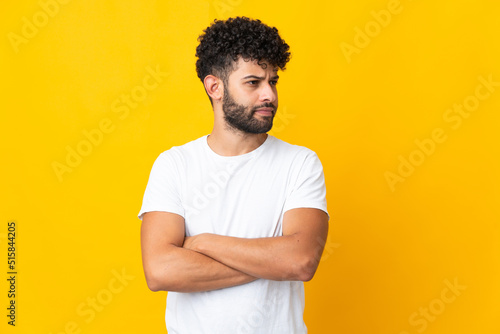 Young Moroccan man isolated on yellow background keeping the arms crossed