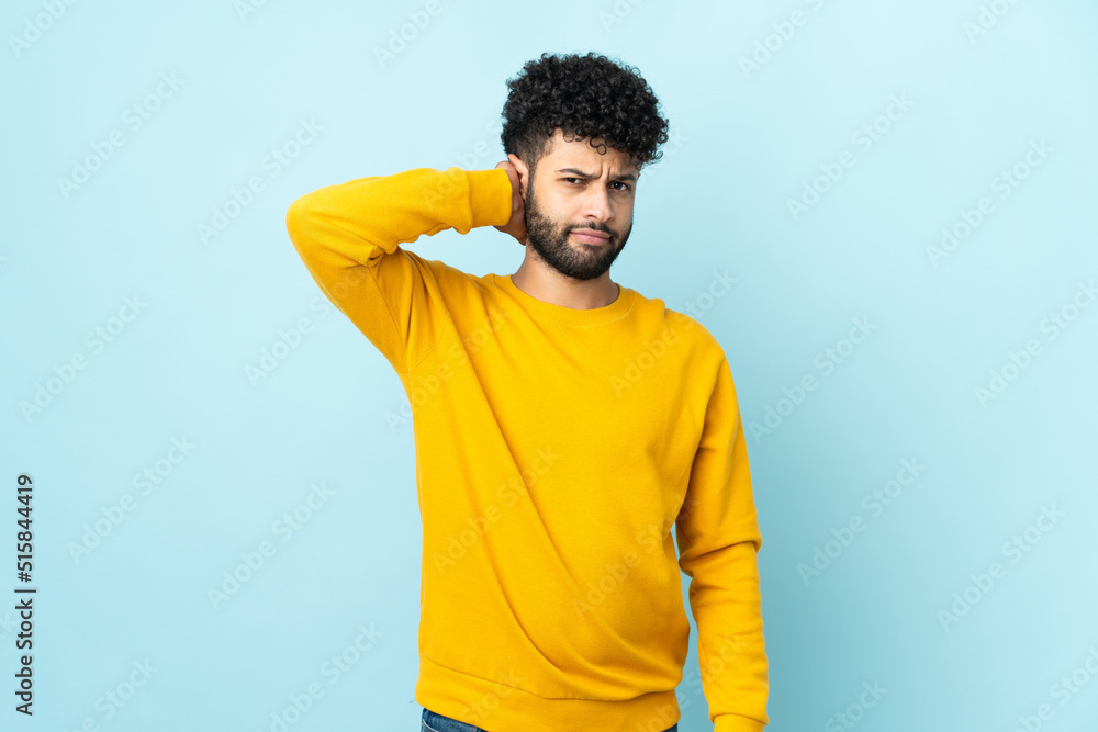 Young Moroccan man isolated on blue background having doubts Young Moroccan man isolated on blue background having doubts
