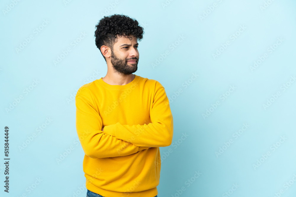 Young Moroccan man isolated on blue background looking to the side Young Moroccan man isolated on blue background looking to the side