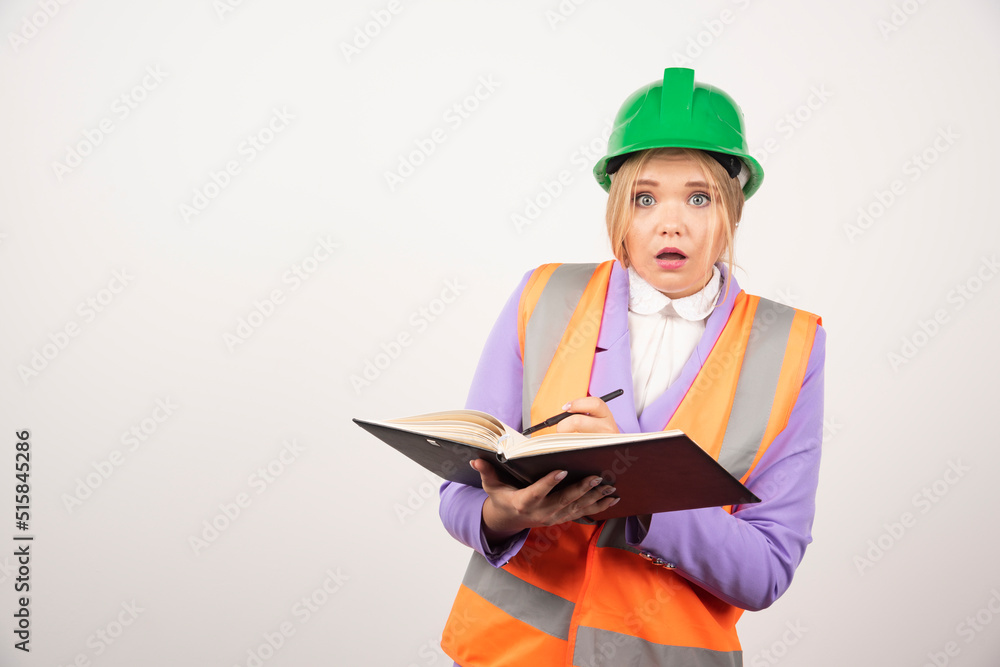 Shocked female builder in hardhat with tablet on white background Shocked female builder in hardhat with tablet on white background