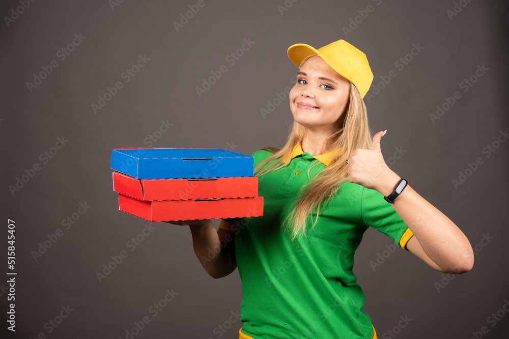 Deliverywoman holding cardboards of pizza and showing thumb up Deliverywoman holding cardboards of pizza and showing thumb up