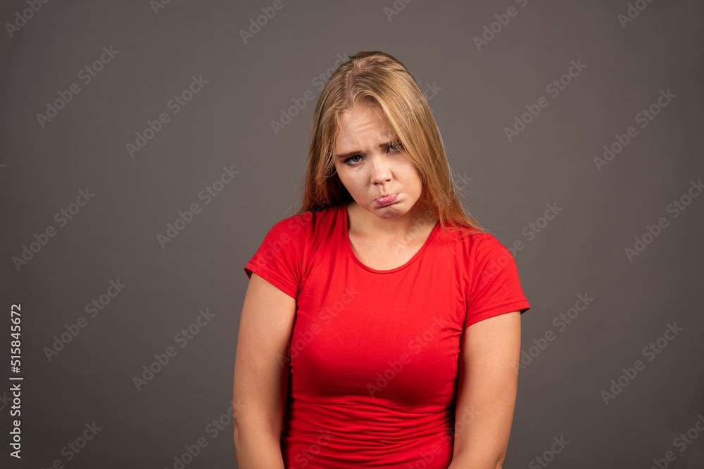 Portrait of upset woman posing over dark background Portrait of upset woman posing over dark background