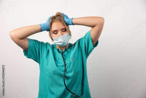 Portrait of upset female doctor wearing protective mask photo