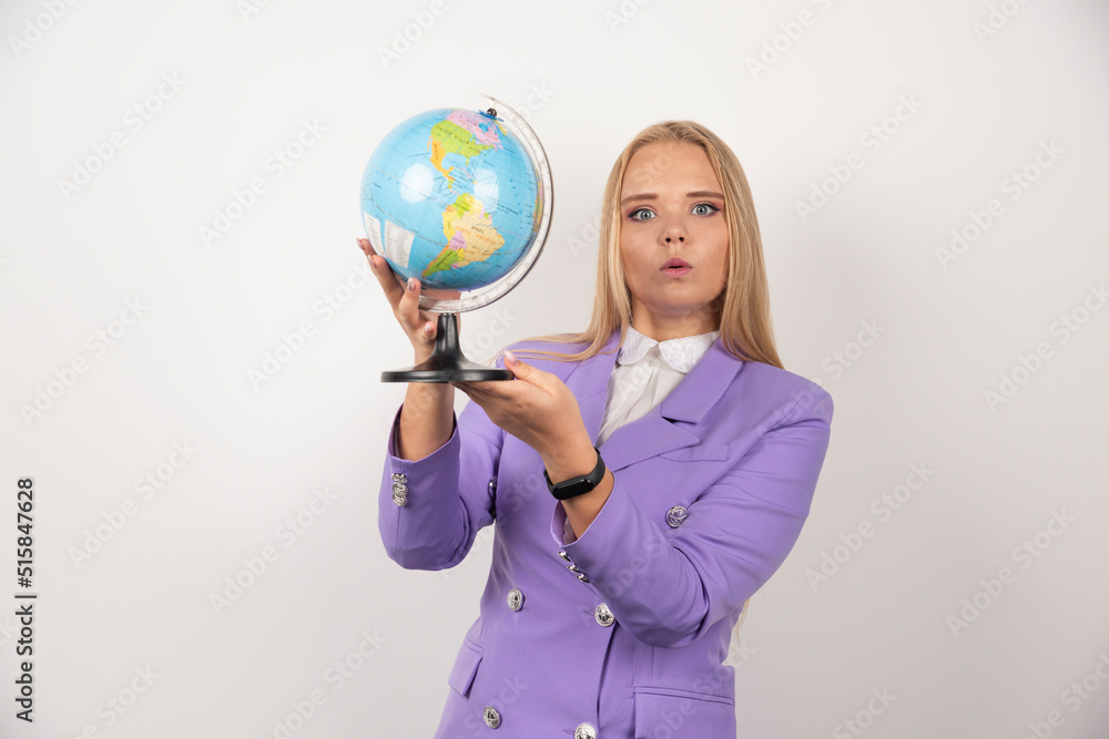 Fototapeta premium Female teacher holding globe on white background