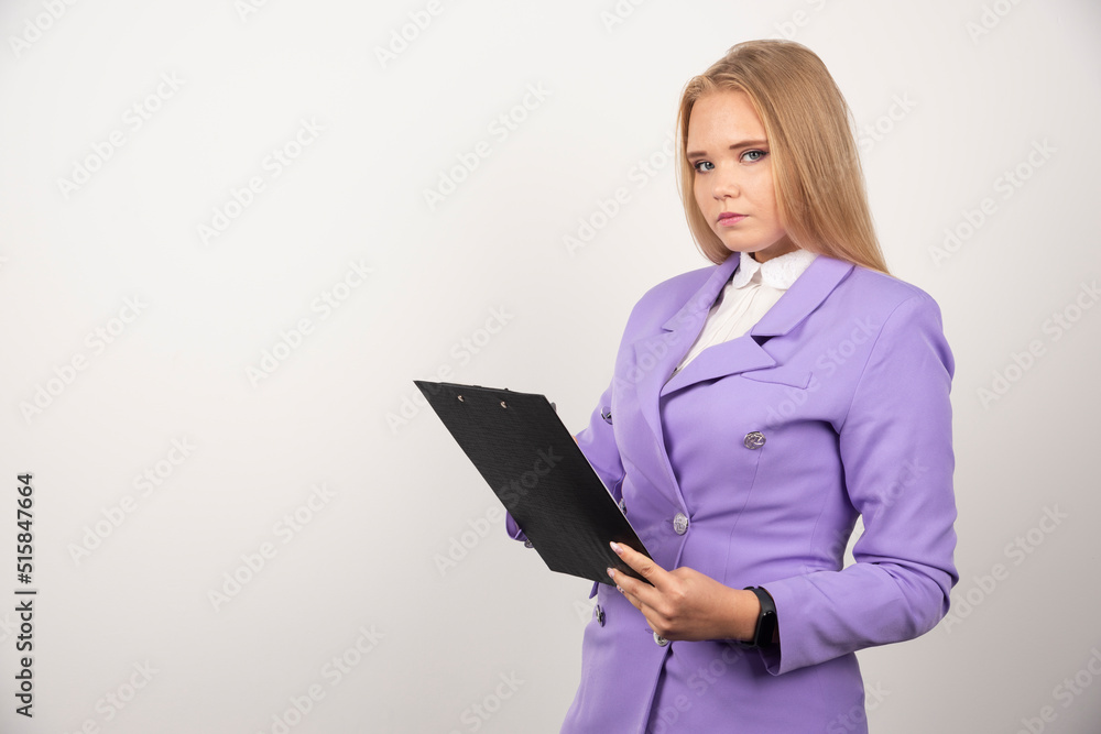 Portrait of young business woman standing and holding clipboard Portrait of young business woman standing and holding clipboard