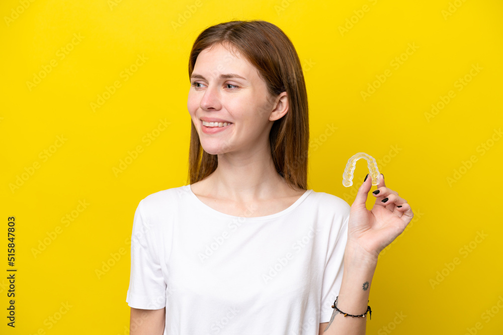 Young English woman holding invisible braces looking side Young English woman holding invisible braces looking side