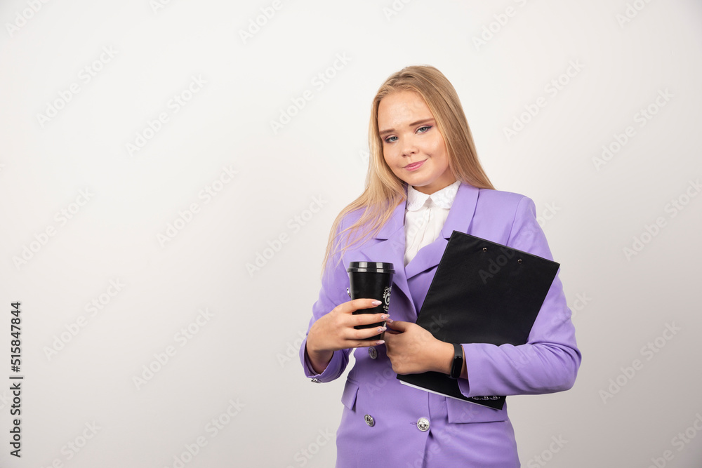 Smiling woman holding cup of coffee and tablet on white background Smiling woman holding cup of coffee and tablet on white background