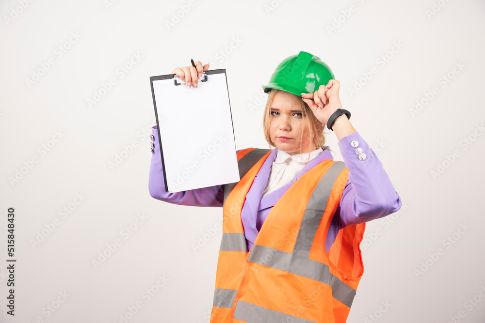 Female contractor with green helmet holding clipboard on white background Female contractor with green helmet holding clipboard on white background