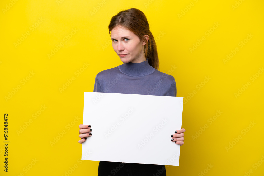 Young English woman isolated on yellow background holding an empty placard Young English woman isolated on yellow background holding an empty placard